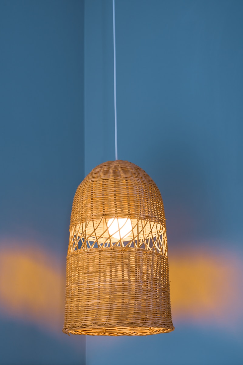 a wicker light hanging from a ceiling